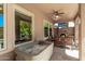 Inviting covered patio with a fireplace, hot tub, and outdoor seating at 12903 W Brookhart Way, Peoria, AZ 85383