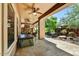 Covered patio featuring an outdoor fireplace, hot tub, and lush desert landscaping at 12903 W Brookhart Way, Peoria, AZ 85383