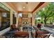Cozy covered patio with stone fireplace, ceiling fan, and comfortable seating at 12903 W Brookhart Way, Peoria, AZ 85383
