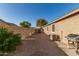 Private backyard with gravel, greenery, and grill, perfect for relaxation and outdoor entertaining at 13153 W Cottontail Ln, Peoria, AZ 85383