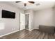 Neutral bedroom featuring wood floors, TV, and an open door showing a spacious layout at 13153 W Cottontail Ln, Peoria, AZ 85383