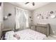 Stylized bedroom featuring flowers, a changing table, and window with natural light at 13153 W Cottontail Ln, Peoria, AZ 85383