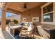 Cozy covered patio perfect for outdoor entertaining with comfortable seating and a ceiling fan at 13153 W Cottontail Ln, Peoria, AZ 85383