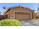 Two-car garage with decorative details, set amidst a landscaped front yard enhancing curb appeal at 13153 W Cottontail Ln, Peoria, AZ 85383