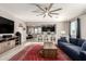 Open-concept living room with stylish decor, ceiling fan, and ample natural light at 13153 W Cottontail Ln, Peoria, AZ 85383
