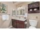 Well-lit bathroom with a vanity, dark wood cabinet, and framed mirror at 15095 N Thompson Peak Pkwy # 1005, Scottsdale, AZ 85260