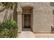 Charming front door with wreath, complemented by textured wall and verdant shrubbery at 15095 N Thompson Peak Pkwy # 1005, Scottsdale, AZ 85260