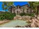 Attractive building with landscaped water feature, mature trees, and charming architectural details at 15095 N Thompson Peak Pkwy # 1005, Scottsdale, AZ 85260