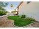 Backyard featuring desert landscaping, vibrant green grass, and outdoor dining area at 15211 N 89Th Ave, Peoria, AZ 85381