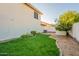 Backyard featuring lush green grass and desert landscaping along a neutral-colored home at 15211 N 89Th Ave, Peoria, AZ 85381