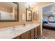 Well-lit bathroom featuring double sinks, two vanity mirrors, and en suite access at 15211 N 89Th Ave, Peoria, AZ 85381