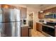 Kitchen featuring stainless steel appliances, brown cabinets, and tile flooring at 15211 N 89Th Ave, Peoria, AZ 85381