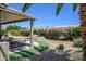 Covered back patio overlooking a beautifully landscaped yard with a waterfall feature at 15658 W Arbor Trl, Surprise, AZ 85374