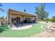 Extended covered patio and lush, green turf, ideal for outdoor living and relaxation in a private backyard at 15658 W Arbor Trl, Surprise, AZ 85374