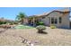 Backyard oasis with stone accents, mature shrubs, and covered patio at 15658 W Arbor Trl, Surprise, AZ 85374