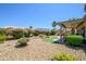 Lush backyard with a rock waterfall, mature flowering bushes, and a covered patio, perfect for relaxation at 15658 W Arbor Trl, Surprise, AZ 85374