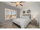 Comfortable bedroom with a ceiling fan, plantation shutters, and carpeted floors, creating a cozy retreat at 15658 W Arbor Trl, Surprise, AZ 85374