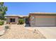 Beautiful one-story home showcasing desert landscaping and a beige exterior with a two-car garage at 15658 W Arbor Trl, Surprise, AZ 85374