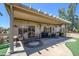 Spacious covered patio featuring multiple seating areas and views of the beautifully landscaped backyard at 15658 W Arbor Trl, Surprise, AZ 85374