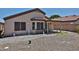 Backyard featuring low-maintenance desert landscaping and covered patio area, ready for transformation at 16242 W Caribbean Ln, Surprise, AZ 85379