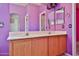 Bathroom with double vanity sinks, wood cabinets, and two mirrors at 16242 W Caribbean Ln, Surprise, AZ 85379