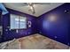 A bedroom with peeling, dark blue paint and damaged flooring shows renovation potential at 16242 W Caribbean Ln, Surprise, AZ 85379