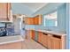 Kitchen with stainless steel appliances and neutral countertops with oak cabinetry at 16242 W Caribbean Ln, Surprise, AZ 85379