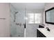 Bathroom showcasing a tiled shower with glass door and window for natural light at 1640 W Gail Dr, Chandler, AZ 85224
