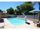 Outdoor swimming pool with clear blue water, a basketball hoop, and a patio area under a sunny sky at 1640 W Gail Dr, Chandler, AZ 85224