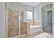 Spacious bathroom features a glass-enclosed shower and a luxurious soaking tub at 18108 W Thunderhill Pl, Goodyear, AZ 85338