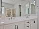 Bathroom showcasing a double vanity with white cabinets, complemented by a large mirror at 18108 W Thunderhill Pl, Goodyear, AZ 85338