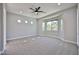 Bright bedroom with plush carpeting, ample natural light, and a modern ceiling fan at 18108 W Thunderhill Pl, Goodyear, AZ 85338