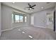 Comfortable bedroom features a ceiling fan, natural lighting, and direct access to the outdoors at 18108 W Thunderhill Pl, Goodyear, AZ 85338