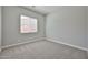 Comfortable bedroom with neutral decor, plush carpet, and a window providing natural light at 18108 W Thunderhill Pl, Goodyear, AZ 85338