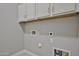 Functional laundry room with overhead cabinets and utility connections for efficient chores at 18108 W Thunderhill Pl, Goodyear, AZ 85338