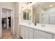 Double sink in main bathroom with white cabinets, a large mirror and a walk-in closet at 1825 E Hampton Ln # 108, Gilbert, AZ 85295