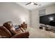 Cozy bedroom with a brown leather sofa, ceiling fan, and plush carpeting at 1825 E Hampton Ln # 108, Gilbert, AZ 85295