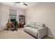 Spare bedroom with a gray sofa, desk, and bookcase with ample natural light at 1825 E Hampton Ln # 108, Gilbert, AZ 85295