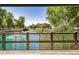 Scenic view of a community pond with fountains, lush greenery, and a wooden fence, offering a tranquil atmosphere at 1825 E Hampton Ln # 108, Gilbert, AZ 85295