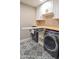 This laundry room boasts black front load laundry machines and a pull out ironing board built into the counter at 1849 S 96Th St, Mesa, AZ 85209