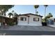 Charming single-story home featuring cream siding, red trim, a concrete driveway, and desert landscaping at 2060 N Center St # 275, Mesa, AZ 85201