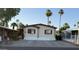 Charming single-story home featuring cream siding, red trim, a concrete driveway, and desert landscaping at 2060 N Center St # 275, Mesa, AZ 85201