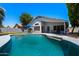 The spacious backyard has a sparkling pool, covered patio, lush landscaping, and privacy, perfect for outdoor living at 2111 E Rawhide St, Gilbert, AZ 85296