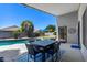Backyard covered patio area with a dining table set overlooking the pool, perfect for relaxation and outdoor entertaining at 2111 E Rawhide St, Gilbert, AZ 85296