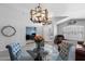 Elegant dining room featuring a glass table, tufted chairs, and a modern chandelier at 2111 E Rawhide St, Gilbert, AZ 85296