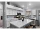 Bright kitchen with stainless appliances, white cabinetry, quartz countertops and gray island at 2111 E Rawhide St, Gilbert, AZ 85296
