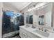Modern main bathroom with a walk-in shower, dual sinks, and stylish tile at 2111 E Rawhide St, Gilbert, AZ 85296