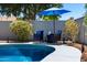 A beautiful backyard pool area with lounge chairs, landscaping, and privacy wall, perfect for relaxation at 2111 E Rawhide St, Gilbert, AZ 85296