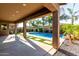 Covered back patio with a view of the sparkling pool, palm trees, and synthetic grass at 22944 E Via Del Oro --, Queen Creek, AZ 85142
