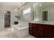 Bright bathroom with tub, dark wood cabinets, and white countertops at 22944 E Via Del Oro --, Queen Creek, AZ 85142